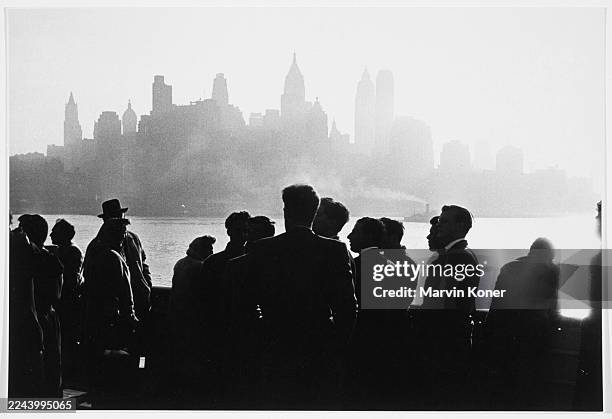 Passengers aboard a ship sailing from Napoli, Italy to America gather to see the New York City skyline as they arrive in New York in 1957.