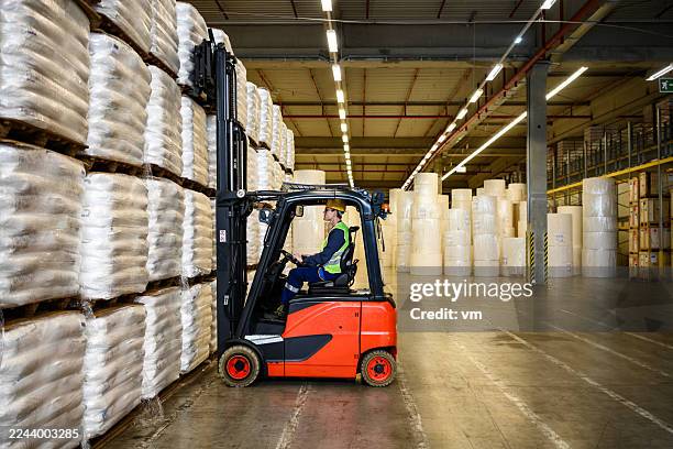 industrial forklift operator in warehouse - forklift truck stock pictures, royalty-free photos & images