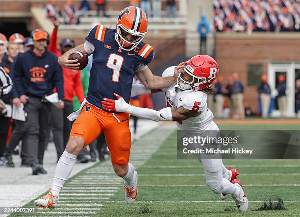 Luke Altmyer of the Illinois Fighting Illini runs the ball against Kaj Sanders of the Rutgers Scarlet Knights during the first half of the NCAA...