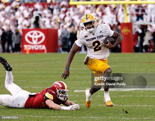 Quarterback Jeff Sims of the Arizona State Sun Devils breaks away from linebacker Cael Brezina of the Iowa State Cyclones as he scrambles for yards...