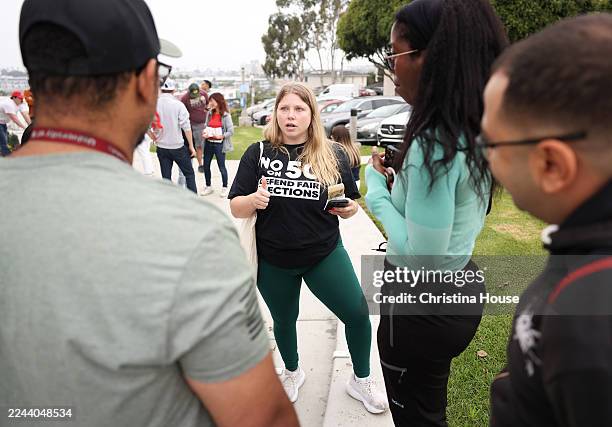 Ariana Assenmacher, of California Young Republicans, center, organizes during a gathering of Republican Party members pressing to vote no on...