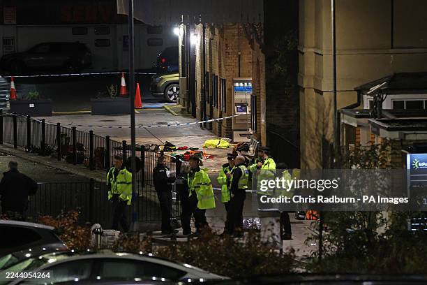 Group of police officers stand close to the emergency equipment left behind after an incident at Huntingdon train station in Cambridgeshire, wherea...