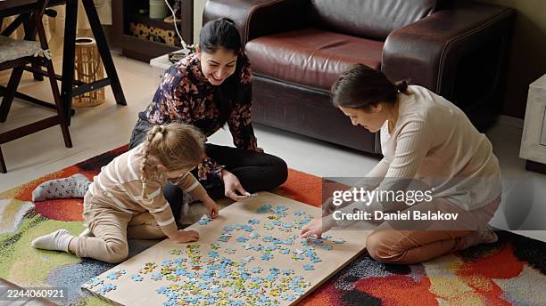 family-friendly games. fun leisure time doing jigsaw puzzle - iranian people stock pictures, royalty-free photos & images