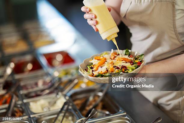 pouring dressing on fresh salad at restaurant salad bar - salad dressing stock pictures, royalty-free photos & images