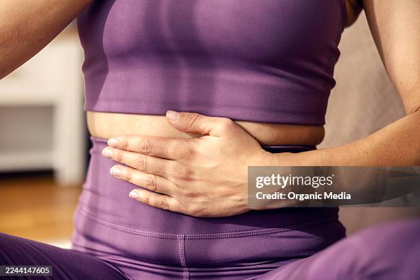 mujer practicando respiración profunda para el bienestar y la relajación - estómago fotografías e imágenes de stock