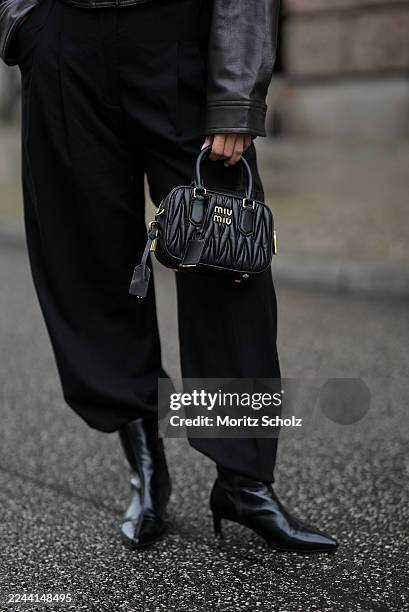 Bella Emar is seen wearing a dark brown cropped leather jacket with a high collar, shoulder tabs and front flap pockets by Zara; high-waisted black...