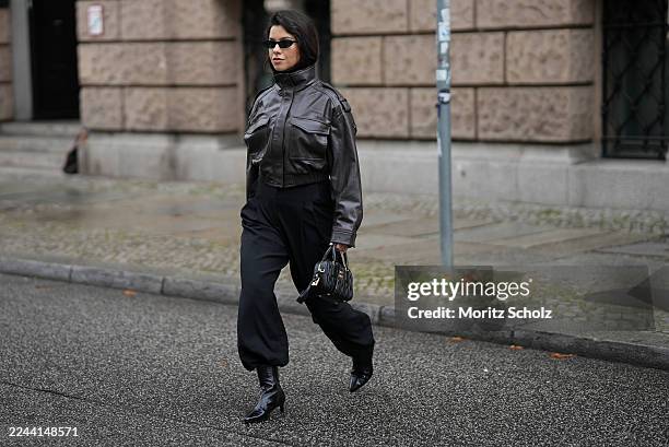 Bella Emar is seen wearing a dark brown cropped leather jacket with a high collar, shoulder tabs and front flap pockets by Zara; high-waisted black...