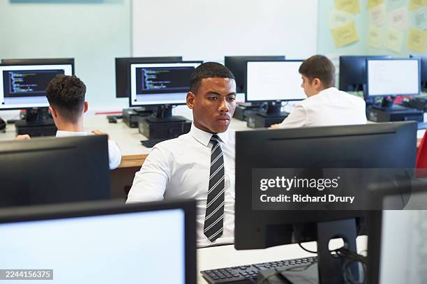 male high school student working in a computer lab - computer lab high school with computer screen photos et images de collection