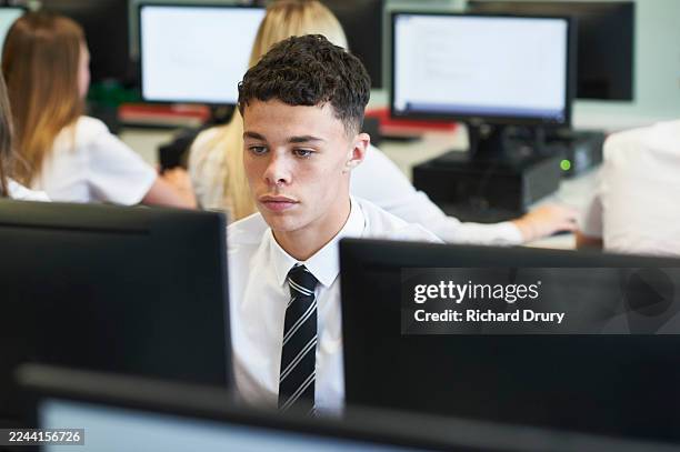 male high school student in a computer lab - computer lab high school with computer screen photos et images de collection