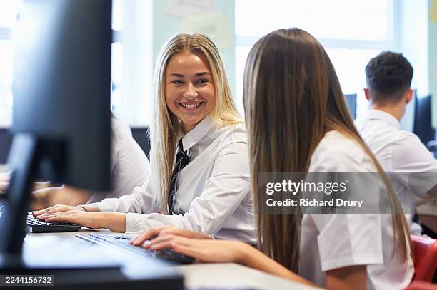cheerful schoolgirl talking to her friend in a computer lab - computer lab high school with computer screen photos et images de collection