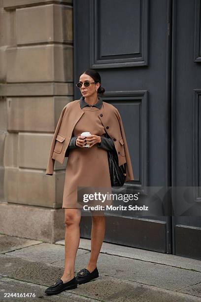 Patricia Wirschke is seen wearing a camel colored short coat jacket by C. Wirschke; a camel colored tailored wool dress with a straight silhouette by...