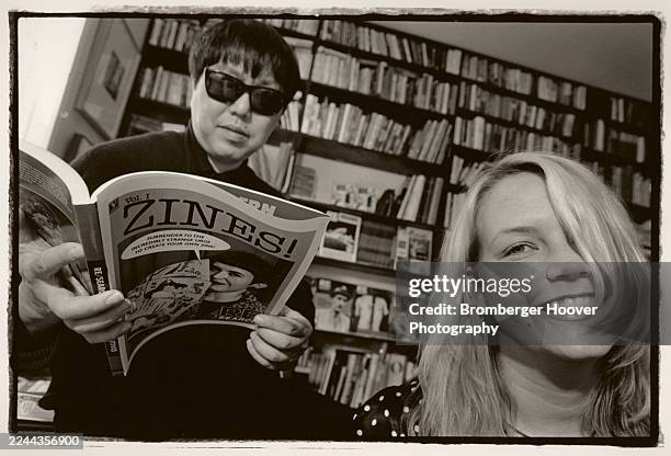 Portrait of American publisher & editor V Vale , holding a copy of the book 'Zines! Vol I' as he poses, with publicist Barbara MacDonald, in his...