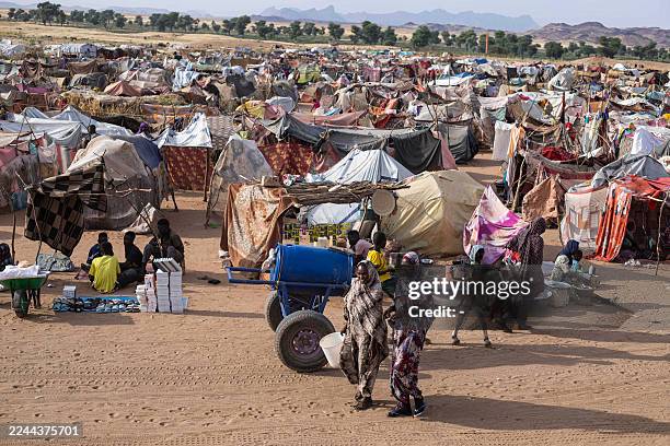 Displaced Sudanese who fled El-Fasher after the city fell to the Rapid Support Forces , walk in the Um Yanqur camp, located on the southwestern edge...