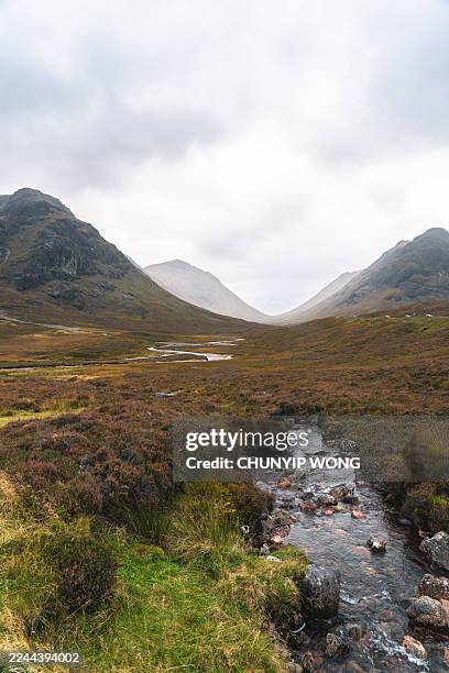 glencoe valley stream flowing through scottish highlands - glencoe stock pictures, royalty-free photos & images