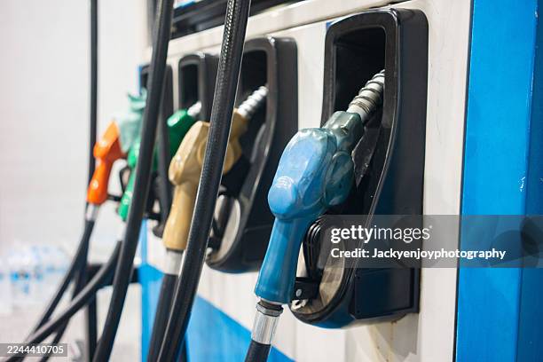 the gasoline filler neck has a refueling valve installed. white vehicle filling up with fuel at a petrol station - bomba de combustible fotografías e imágenes de stock