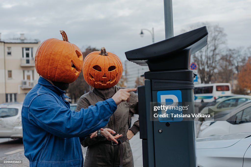 Halloween Pumpkin-Head Friends At A Parking Meter In An Urban Parking Lot