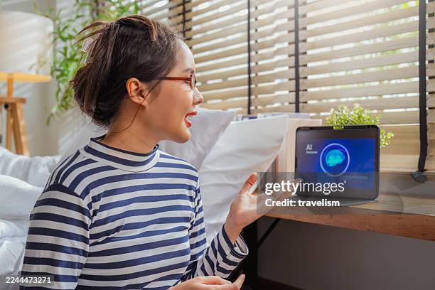 professional woman sits on floor utilizing ai-powered assistant on smartphone and tablet for automated workflow optimization, leveraging cutting-edge machine learning technology for business productivity - deep conversation stock pictures, royalty-free photos & images