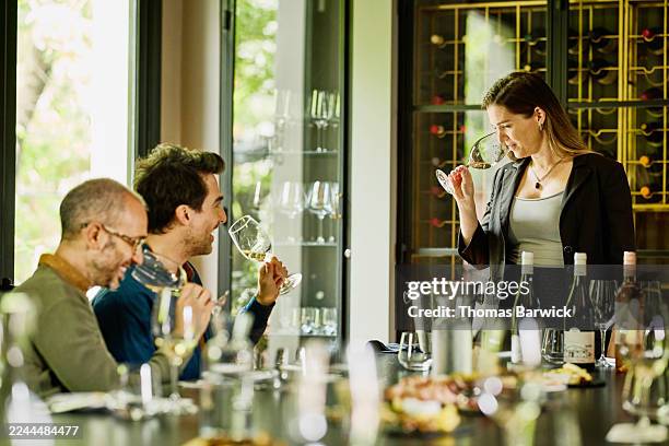 medium wide shot sommelier teaching and smelling wine at tasting - wine tasting stock pictures, royalty-free photos & images