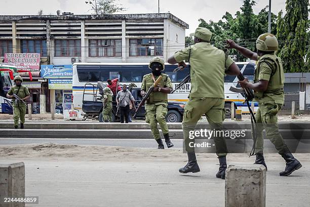 Tanzanian police officers try to disperse protesters amid clashes in Dar es Salaam on October 29 during Tanzania's presidential elections. Hundreds...