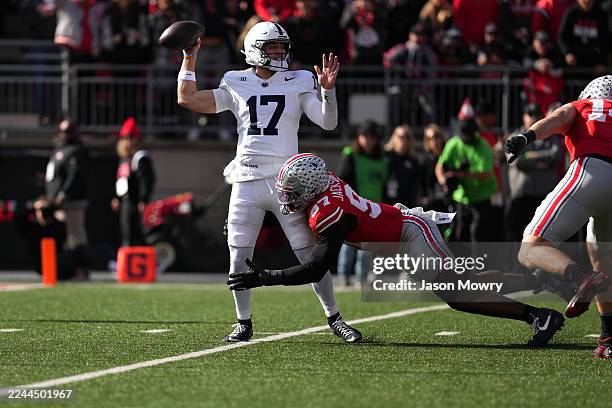 Quarterback Ethan Grunkemeyer of the Penn State Nittany Lions passes the ball while being tackled by Defensive end Kenyatta Jackson Jr. #97 of the...