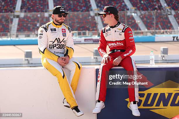 Taylor Gray, driver of the Operation 300 Toyota, and Jesse Love, driver of the Whelen Chevrolet, talk on the grid during qualifying for the NASCAR...