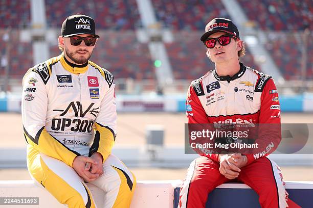 Taylor Gray, driver of the Operation 300 Toyota, and Jesse Love, driver of the Whelen Chevrolet, talk on the grid during qualifying for the NASCAR...