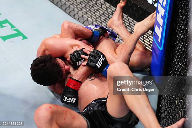 Allan Nascimento of Brazil secures a submission against Cody Durden in a 130-pound catchweight fight during the UFC Fight Night event at UFC APEX on...