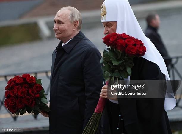 Russian President Vladimir Putin and Russian Orthodox Patriarch Kirill place flowers at the monument of Minin and Pozharsky at Red Square on November...