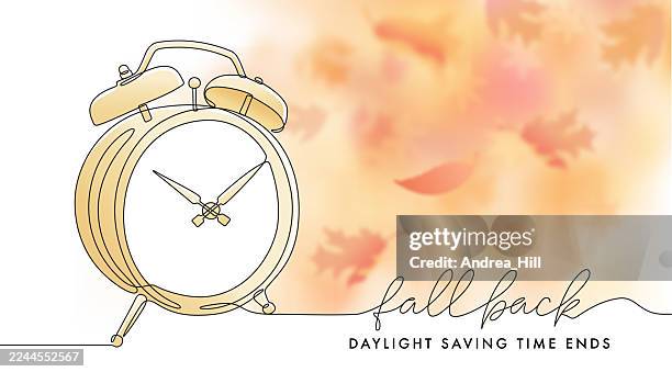 fall back daylight saving time reminder message with alarm clock and bokeh falling leaves - fall back stock illustrations