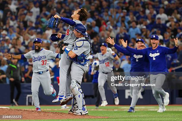 Yoshinobu Yamamoto and Will Smith of the Los Angeles Dodgers celebrate with teammates after defeating the Toronto Blue Jays 5-4 in game seven of the...