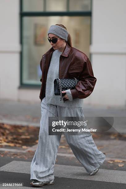 Sonia Lyson seen wearing wide-leg grey pinstripe wool pants by The Frankie Shop paired with a soft, fluffy light-grey knit sweater from & Other...