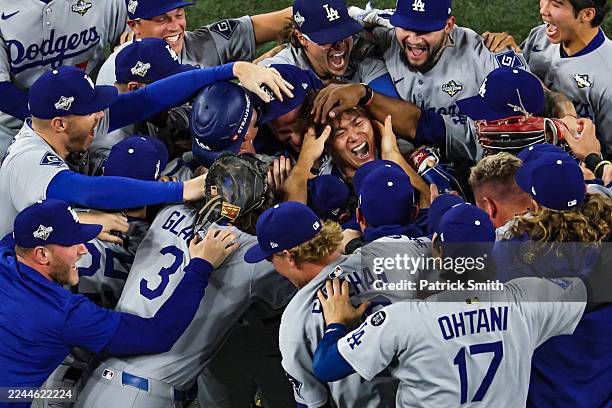 Pitcher Yoshinobu Yamamoto of the Los Angeles Dodgers celebrates with teammates after defeating the Toronto Blue Jays, 5-4, in game seven of the 2025...