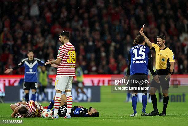 Immanuel Pherai of Hamburger SV is shown a red card by referee Daniel Schlager during the Bundesliga match between 1. FC Köln and Hamburger SV at...