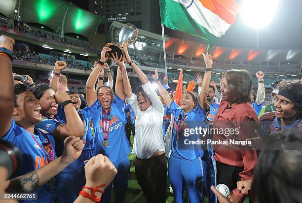 Harmanpreet Kaur of India and former India international cricket player Anjum Chopra celebrate with the ICC Women's Cricket World Cup trophy after...