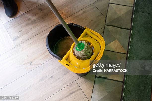 mop soaking in bucket filled with soapy water. - bodenwischer stock-fotos und bilder