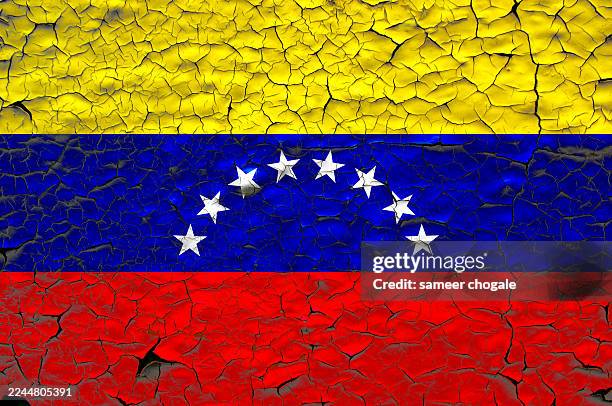 Venezuela flag painted over cracked concrete wall.