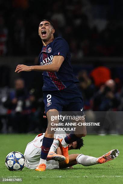 Paris Saint-Germain's Moroccan defender Achraf Hakimi reacts as he is tackled by Bayern Munich's Colombian forward Luis Diaz during the UEFA...