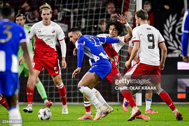 Porto's Turkish forward Deniz Gul fights for the ball with FC Utrecht's Dutch midfielder Gjivai Zechiel and FC Utrecht's Dutch forward David Min...