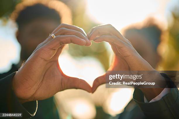 couple forming heart shape with hands against sunlight - valentine card stock pictures, royalty-free photos & images