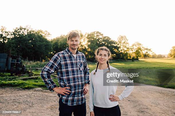 portrait of smiling male and female farmers posing at farm - bauernhaus stock-fotos und bilder