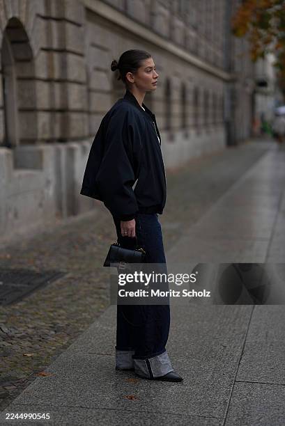 Sophia Geiss is seen wearing a navy bomber jacket with a zip-up front by LeGer by Lena Gercke; Munthe; dark blue cuffed wide-leg jeans by Source...