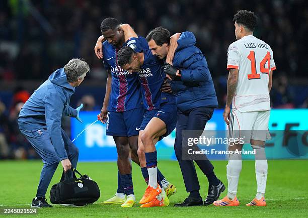 Achraf Hakimi of Paris Saint-Germain is carried off the pitch after picking up an injury upon being fouled by Luis Diaz of Bayern Munich during the...