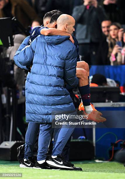 Achraf Hakimi of Paris Saint-Germain is carried off the pitch after picking up an injury upon being fouled by Luis Diaz of Bayern Munich during the...