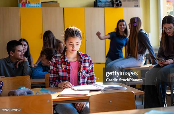 teenage girl experiencing social isolation in a school classroom - peer pressure stock pictures, royalty-free photos & images