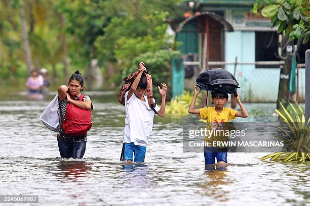 Residents evacuate from their flooded homes due to heavy rain brought by Typhoon Fung-wong in Remedios T. Romualdez, on the southern island of...