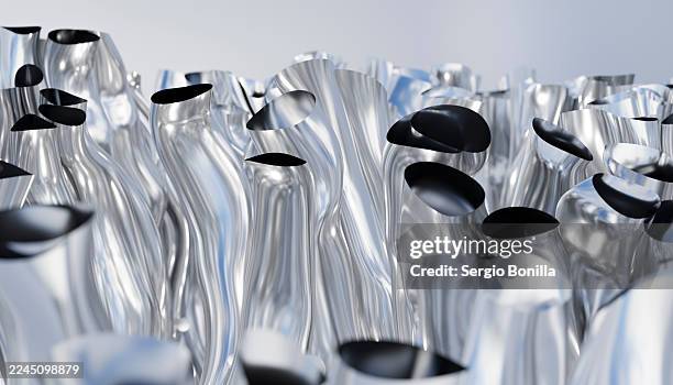 shiny metallic tubes with smooth, wavy surfaces and black openings in abstract arrangement. illustration, rendering - metalworking fluid stock illustrations