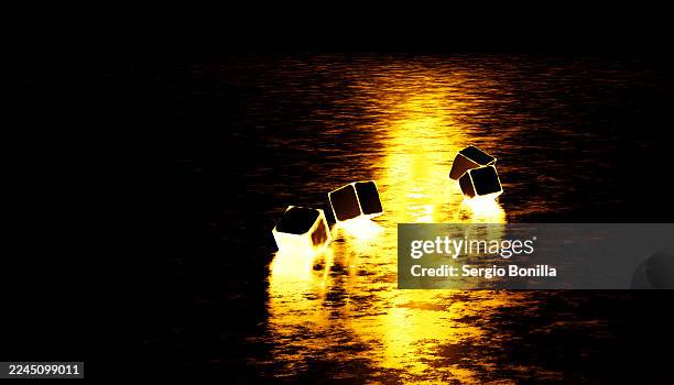 glowing cubes illuminate a dark surface, reflecting warm yellow light on textured water. illustration, rendering - light installation stock illustrations