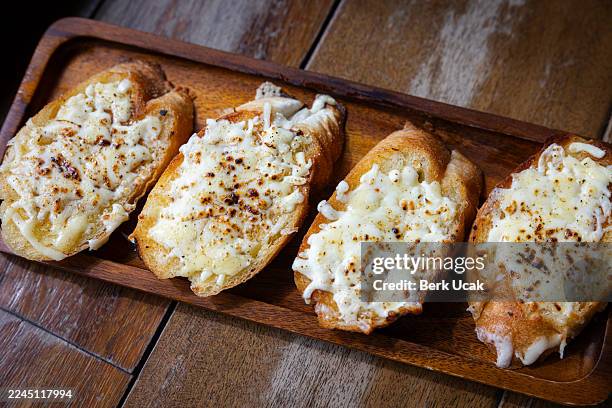 slice of garlic bread served with cheese. - garlic bread stock pictures, royalty-free photos & images