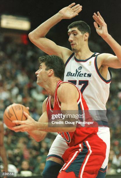 Guard Mark Bradtke of the Philadelphia 76ers tries to get past Georghe Muresan of the Washington Bullets as the Bullets posted a 48-35 halftime lead...