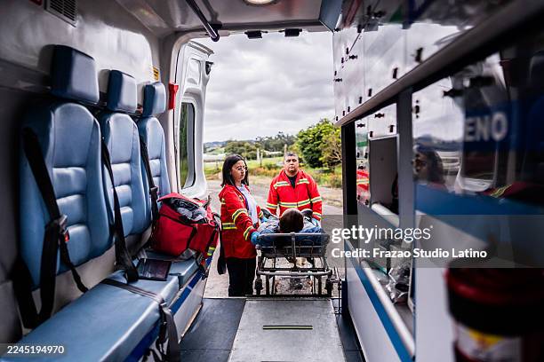 paramedics putting a victim in ambulance after accident - accident victim stock pictures, royalty-free photos & images